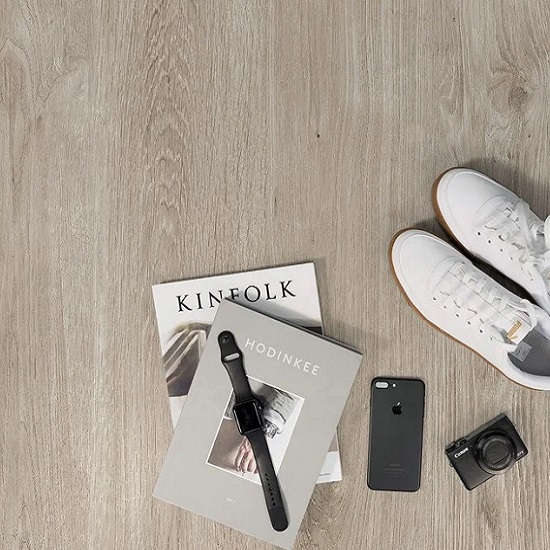 foto de un Suelo Neolith Summer Dala con zapatos blancos, libros y reloj