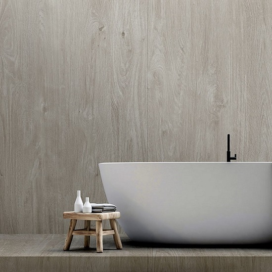 foto de un baño con revestimiento porcelanico Neolith Winter Dala, una silla y una bañera blanca