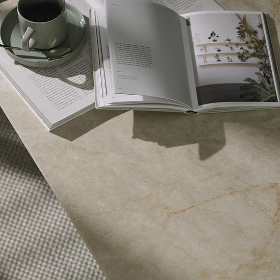 encimera Sapienstone Taj Mahal acabado Cashmere, un libro y una taza