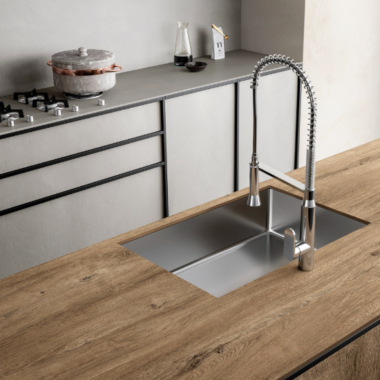 una isla con encimera Sapienstone Rovere Baio en una cocina con muebles blancos
