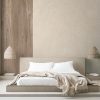 Dormitorio minimalista con pared Arklam Bateig Verona beige, cama blanca, lámparas tejidas y manta beige en ambiente sereno.