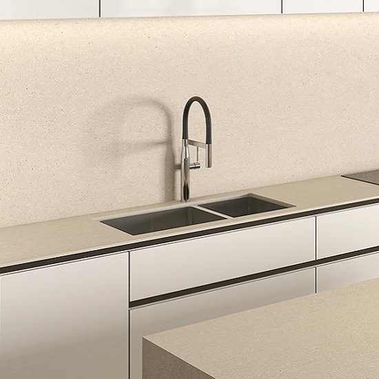 Encimera Arklam Bateig Verona beige con fregadero doble, grifo y gabinetes blancos en cocina moderna.