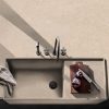 Vista superior de fregadero en encimera Arklam Bateig Verona beige con tabla, cuchillo y cebolla en cocina minimalista.