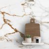 Encimera Arklam Calacatta Gold con tabla de cortar, planta y vela, superficie resistente a manchas para cocinas en Málaga