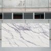 Losa grande de Arklam Lilac blanca veteada en entorno industrial interior.