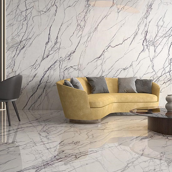 Sala con pared y suelo Arklam Lilac blanca veteada, sofá amarillo y mesa redonda en diseño moderno.