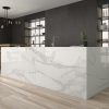 Isla de cocina moderna con encimera Arklam Estatuario en Málaga, diseño elegante con iluminación colgante.