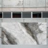 Losa grande de Arklam Invisible Grey gris veteada en entorno industrial interior.