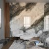 Sala moderna con pared Arklam Invisible Grey gris veteada, sofá gris, sillón y mesa con libros en ambiente luminoso.