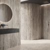 Baño de lujo con encimeras y paredes Arklam Nativa Greige Natural 12 mm, espejo y grifería negra en Málaga.