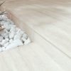 Suelo y escalón con Arklam Nativa White Natural 12 mm en Málaga, decorado con piedras y vegetación.