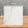 Muestra cuadrada de 10 cm de Dekton Keena sobre fondo gris, con vetas doradas en blanco suave.