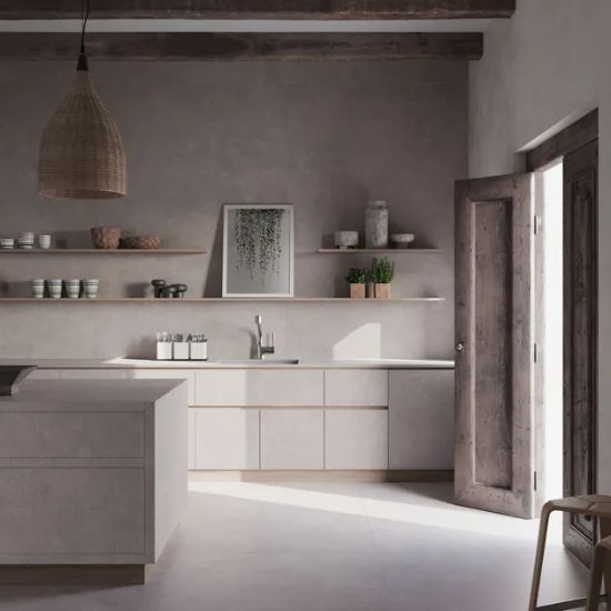Cocina rústica con encimera Neolith Artisan gris, gabinetes blancos, lámpara tejida y estantes decorativos.