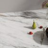 Vista cercana de encimera Neolith Azure blanca con vetas grises y doradas, pera verde, fresas y bol de fruta.