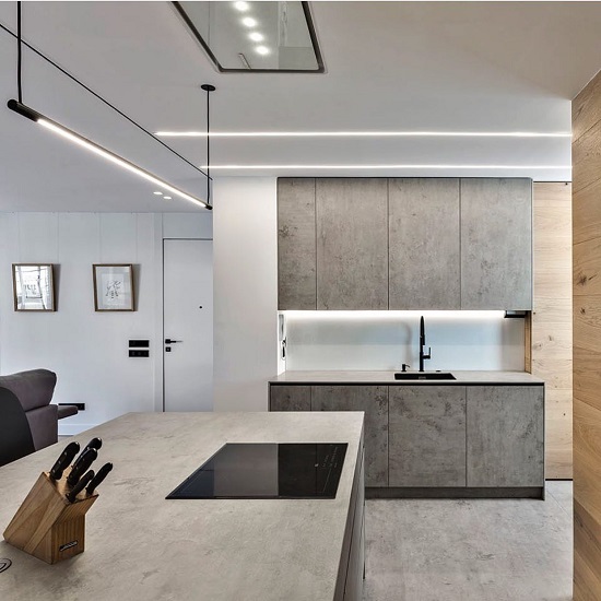 Encimera Neolith Beton en isla de cocina Málaga, diseño gris con madera y fregadero.