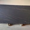 Losa grande de Blaker Luxury Black negra veteada en entorno industrial interior.