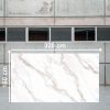 Losa grande de Blaker Statuario Gold 320x160 cm blanca veteada en almacén industrial.