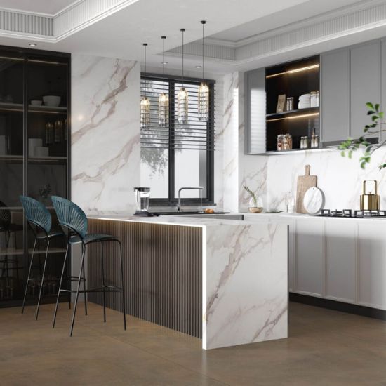 Cocina abierta con isla Blaker Statuario Gold blanca, taburetes de madera, gabinetes blancos y vista a sala en diseño contemporáneo.