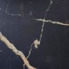 Textura detallada de Blaker Total Cosmic Black negra con vetas doradas en patrón marmóreo intenso