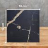 Muestra 10x10 cm de Blaker Total Cosmic Black negra con vetas doradas sobre fondo gris.