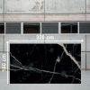 Losa grande de Blaker Total Cosmic Black 320x160 cm negra con vetas doradas en almacén industrial.