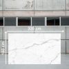 Losa grande de Blaker Statuario Bernini 320x160 cm blanca veteada en almacén industrial.