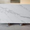 Losa grande de Blaker Statuario Grey blanca veteada en entorno industrial interior.