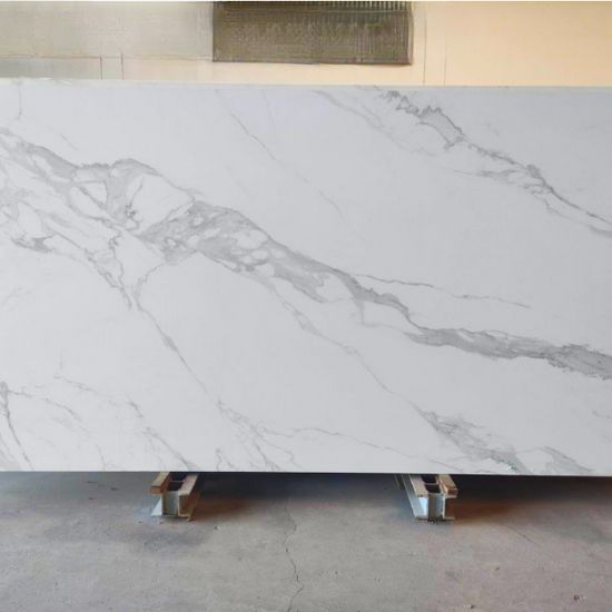 Losa grande de Blaker Statuario Grey blanca veteada en entorno industrial interior.