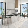 Isla de cocina Blaker Statuario Grey blanca veteada con taburetes blancos, gabinetes marrones y luces doradas en ambiente moderno.