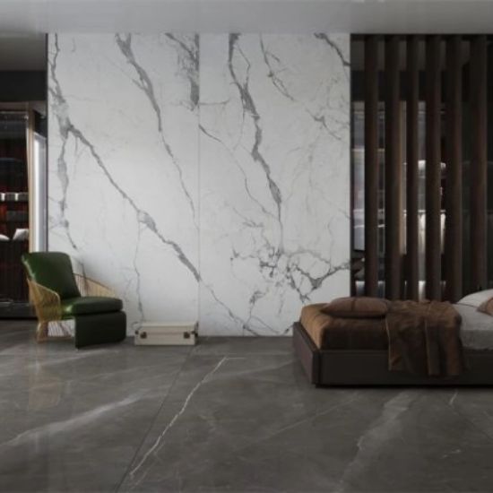 Sala con piso Blaker Statuario Grey blanca veteada, sofá gris, mesa bronce y flores en diseño moderno.