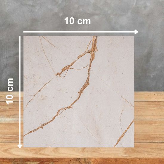 Muestra 10x10 cm de Ceratop Macadamia Cream crema con vetas beiges sobre fondo gris.