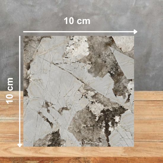 Muestra 10x10 cm de Venux Arctic Patagonia blanca con vetas marrones sobre fondo gris.