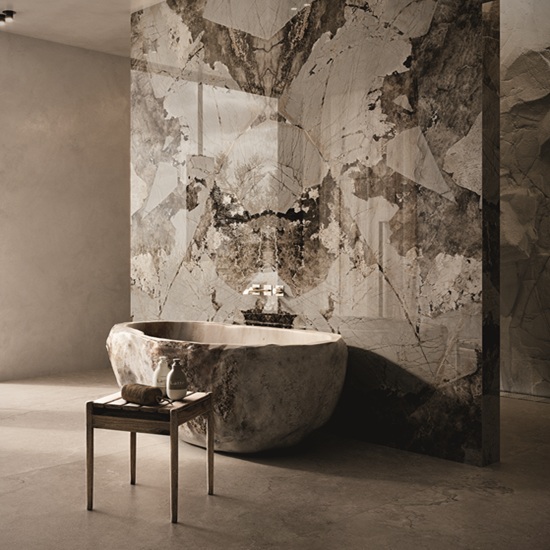 Baño spa con bañera de piedra, grifo plateado y revestimientos Venux Arctic Patagonia blancos con vetas marrones.