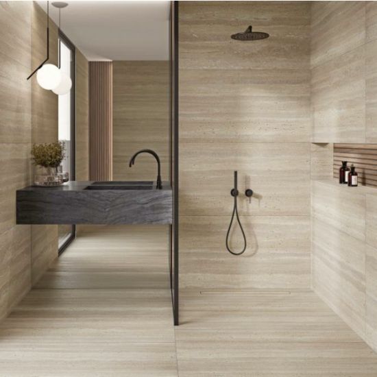 Baño moderno con ducha de vidrio, lavabo negro y revestimientos Blaker Flaminio Dak beige con vetas travertino.