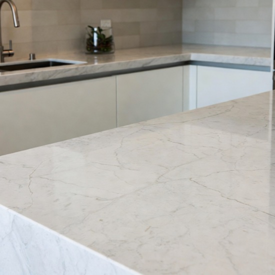 Cocina con encimera de mármol Arctic White, incluyendo isla y salpicadero, para aplicaciones decorativas.