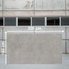 Texto Alternativo Losa grande de Venux Bellissima Grigio 320x160 cm gris veteado en almacén industrial.