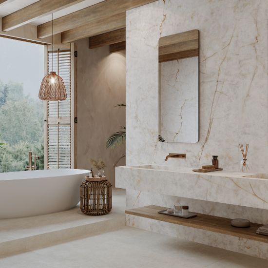 Baño spa con bañera blanca, grifo bronce, espejo redondo y revestimientos Venux Aurora Crystal blancos con vetas doradas.