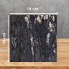 Muestra 10 x 10 cm de Granito Cosmic Black, granito negro con vetas blancas y doradas sobre superficie de madera