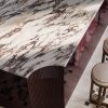 Detalle superior de isla curva en Sapienstone Fior di Viola 4D con veta pasante, mostrando el canto y las vetas continuas en mármol efecto