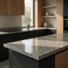 Isla de cocina moderna en Granito Mondariz con muebles negros y madera clara