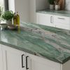 Isla de cocina completa en Sensa Kaira cuarcita verde natural con taburetes y fondo de mármol verde